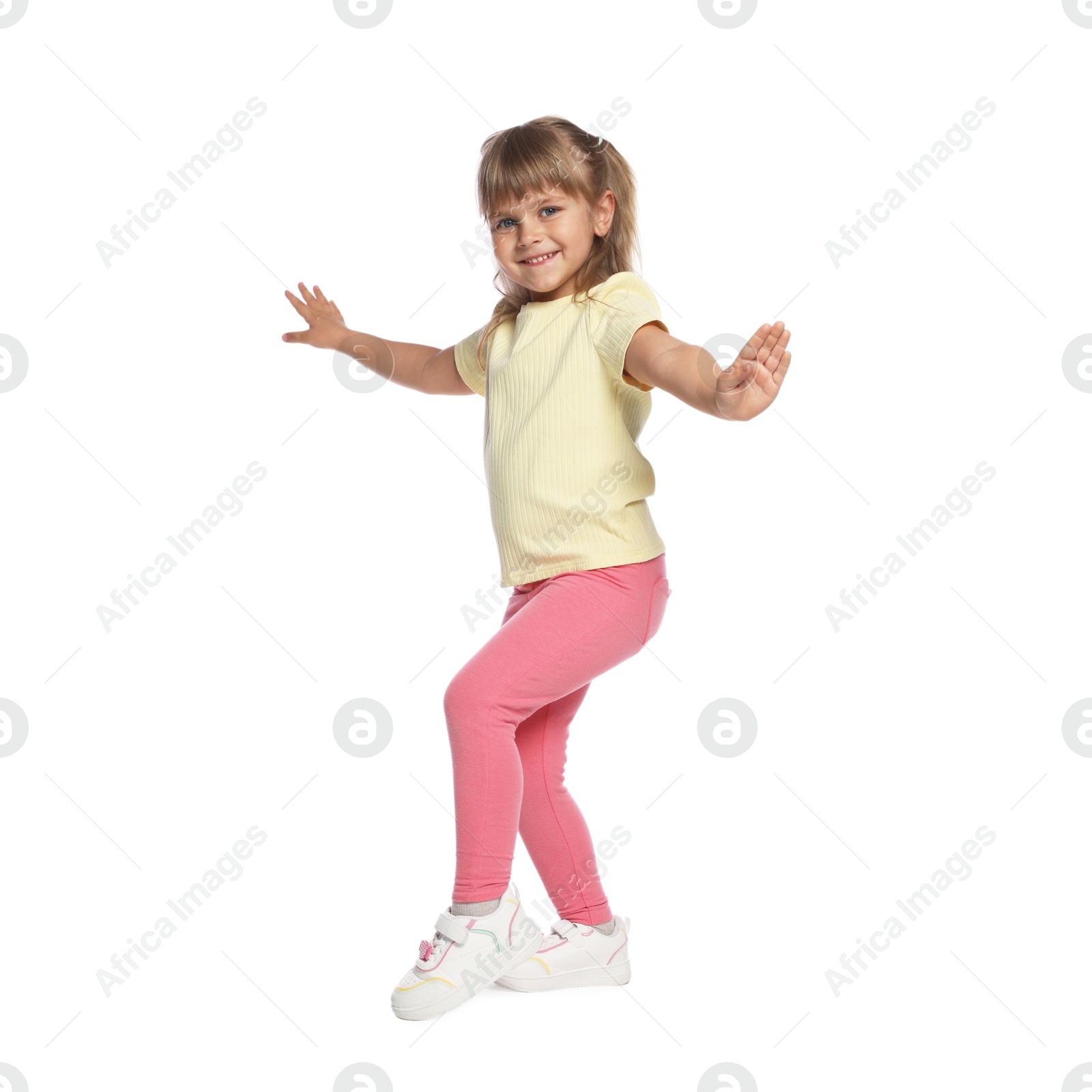 Happy little girl dancing on white background Photo of Happy little girl dancing on white background