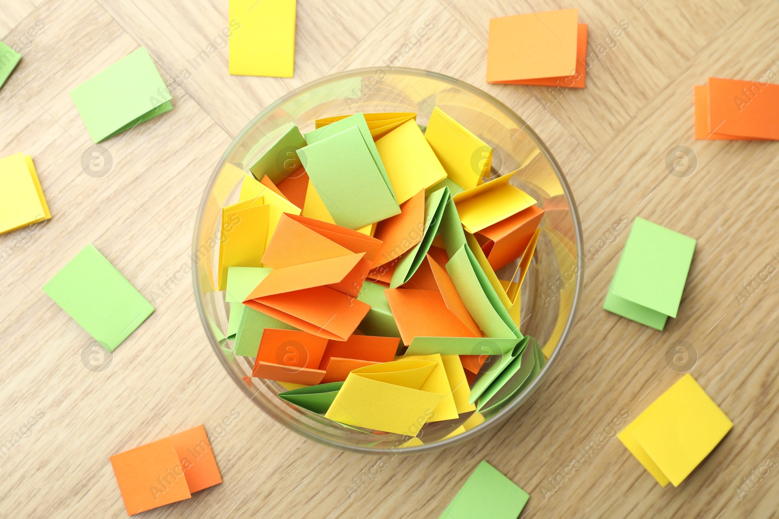 Jar with colorful pieces of paper on wooden table, flat lay Photo of Jar with colorful pieces of paper on wooden table, flat lay