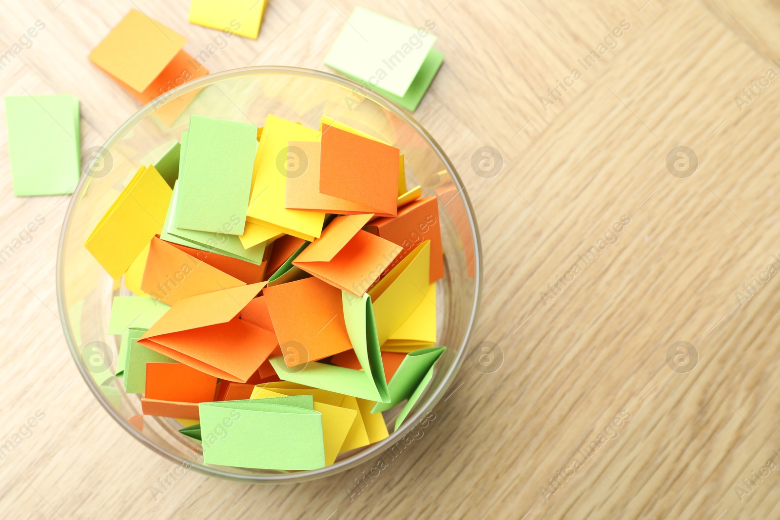 Jar with colorful pieces of paper on wooden table, top view. Space for text Photo of Jar with colorful pieces of paper on wooden table, top view. Space for text