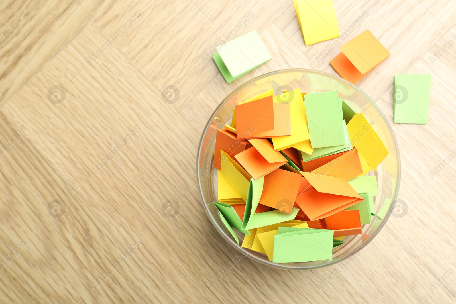 Jar with colorful pieces of paper on wooden table, top view. Space for text Photo of Jar with colorful pieces of paper on wooden table, top view. Space for text