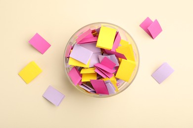Photo of Jar with colorful pieces of paper on beige background, flat lay