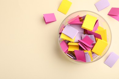 Photo of Jar with colorful pieces of paper on beige background, flat lay. Space for text