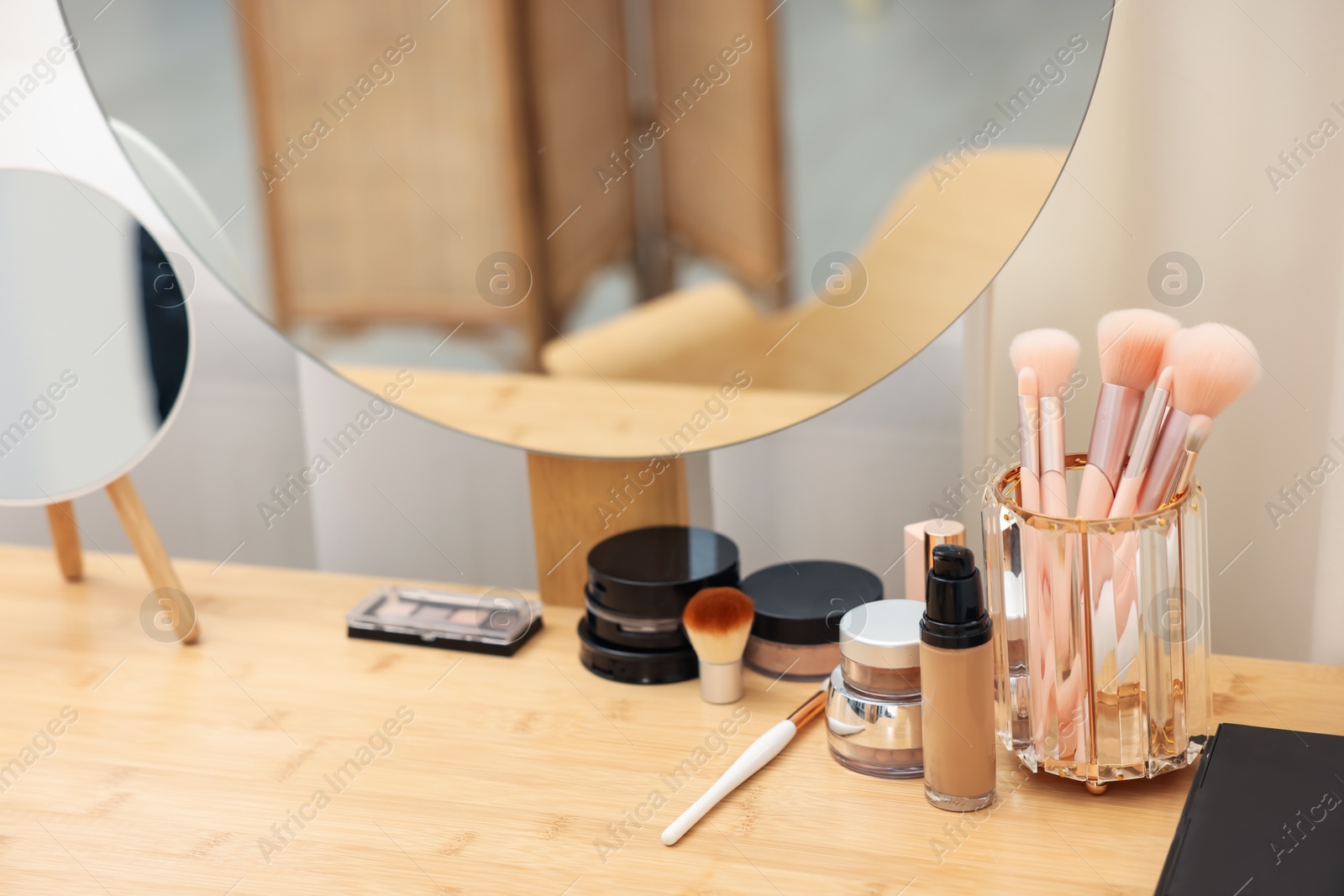 Different makeup products and brushes on vanity indoors, closeup Photo of Different makeup products and brushes on vanity indoors, closeup