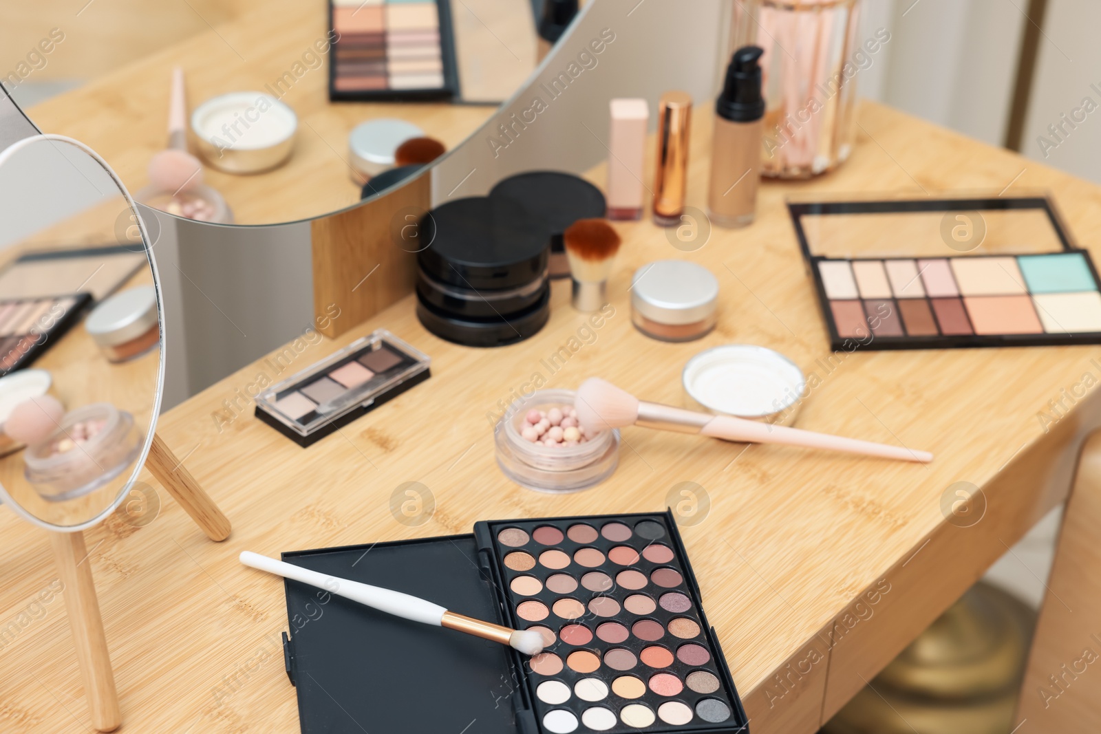 Different makeup products and brushes on vanity indoors, closeup Photo of Different makeup products and brushes on vanity indoors, closeup