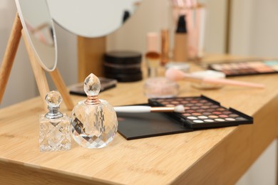 Photo of Different makeup products and brushes on vanity indoors, closeup