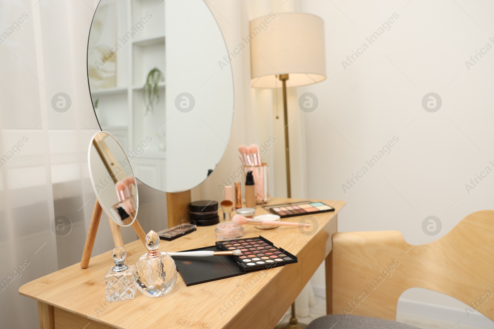 Different makeup products and brushes on vanity indoors Photo of Different makeup products and brushes on vanity indoors