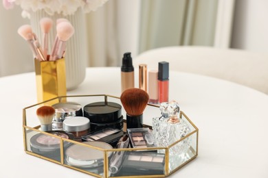 Photo of Tray with different makeup products on white table indoors, closeup