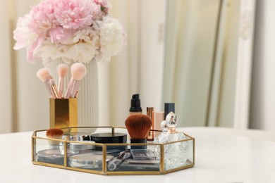 Photo of Tray with different makeup products on white table indoors. Space for text