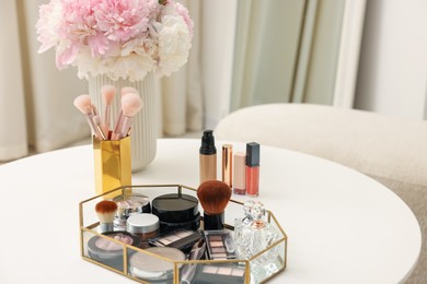 Photo of Tray with different makeup products on white table indoors. Space for text