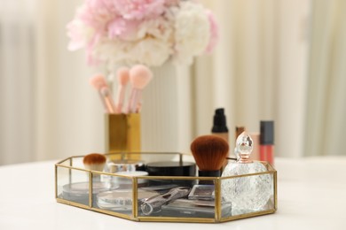 Photo of Tray with different makeup products on white table indoors, closeup