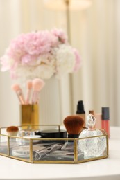 Photo of Tray with different makeup products on white table indoors, closeup