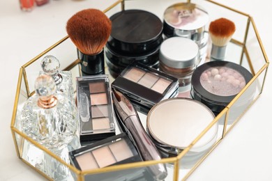Photo of Tray with different makeup products on white table, closeup