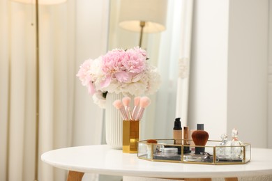 Photo of Tray with different makeup products on white table indoors