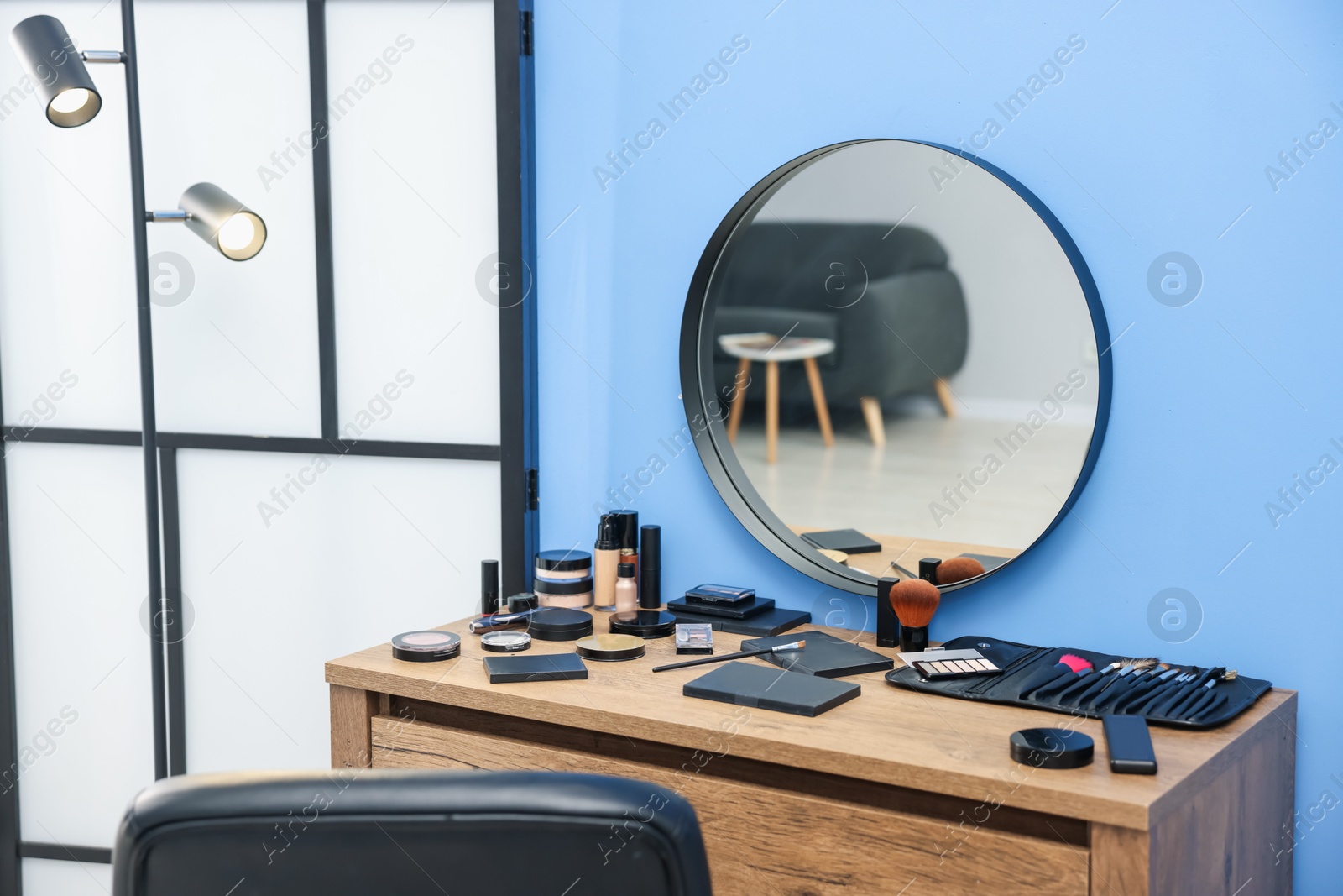 Different makeup products and brushes on vanity indoors Photo of Different makeup products and brushes on vanity indoors