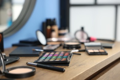 Photo of Different makeup products on wooden table indoors, closeup