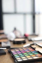 Photo of Different makeup products on wooden table indoors, closeup. Space for text