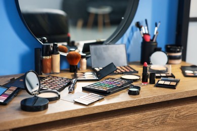 Photo of Different makeup products on vanity indoors, closeup