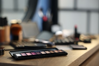 Photo of Different makeup products on wooden table indoors, closeup