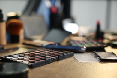 Photo of Different makeup products on wooden table indoors, closeup