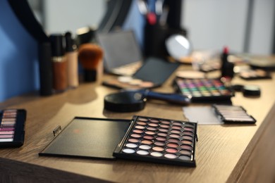 Photo of Different makeup products on wooden table indoors, closeup