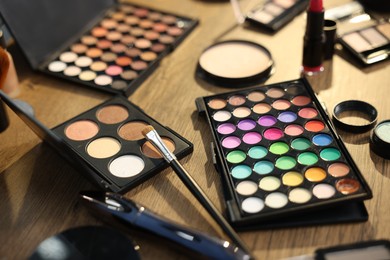 Photo of Different makeup products on wooden table, closeup