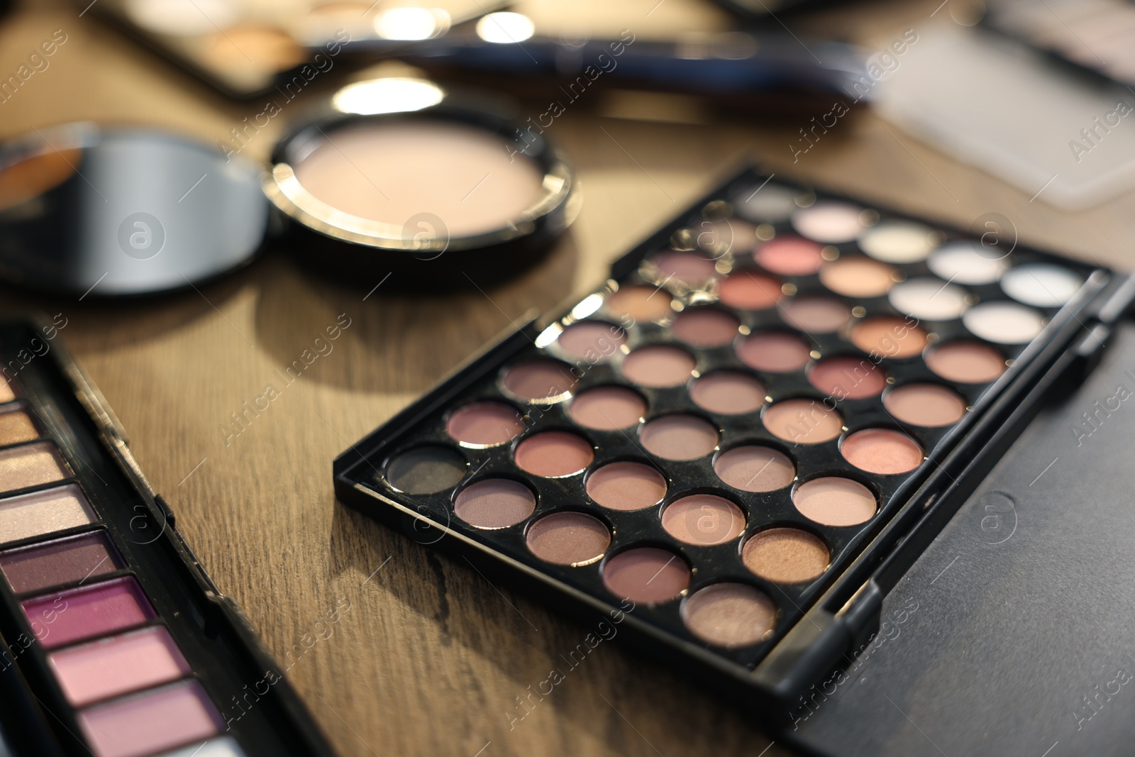 Different makeup products on wooden table, closeup Photo of Different makeup products on wooden table, closeup