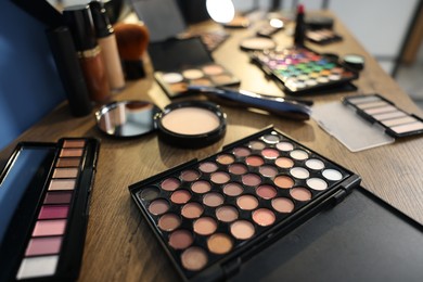Photo of Different makeup products on wooden table indoors, closeup