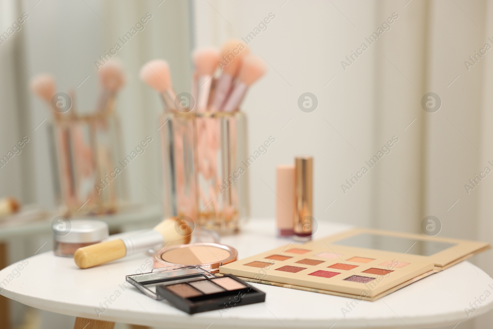 Different makeup products and brushes on white table indoors, closeup Photo of Different makeup products and brushes on white table indoors, closeup