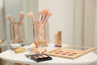 Photo of Different makeup products and brushes on white table indoors, closeup