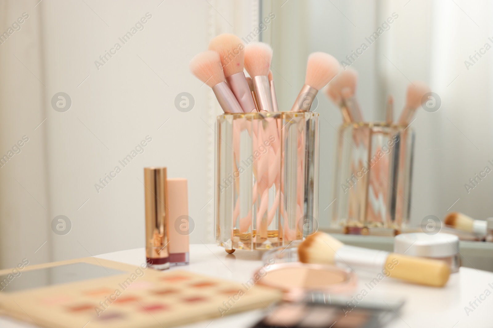 Different makeup products and brushes on white table indoors, closeup Photo of Different makeup products and brushes on white table indoors, closeup