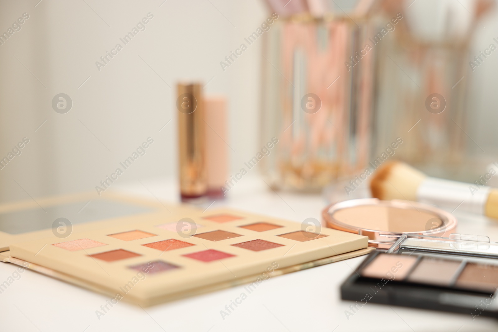 Different makeup products on white table indoors, closeup Photo of Different makeup products on white table indoors, closeup