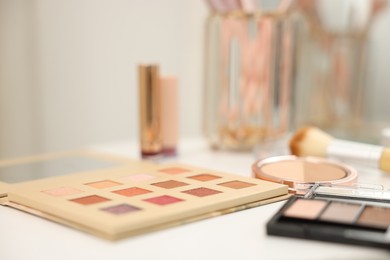Photo of Different makeup products on white table indoors, closeup
