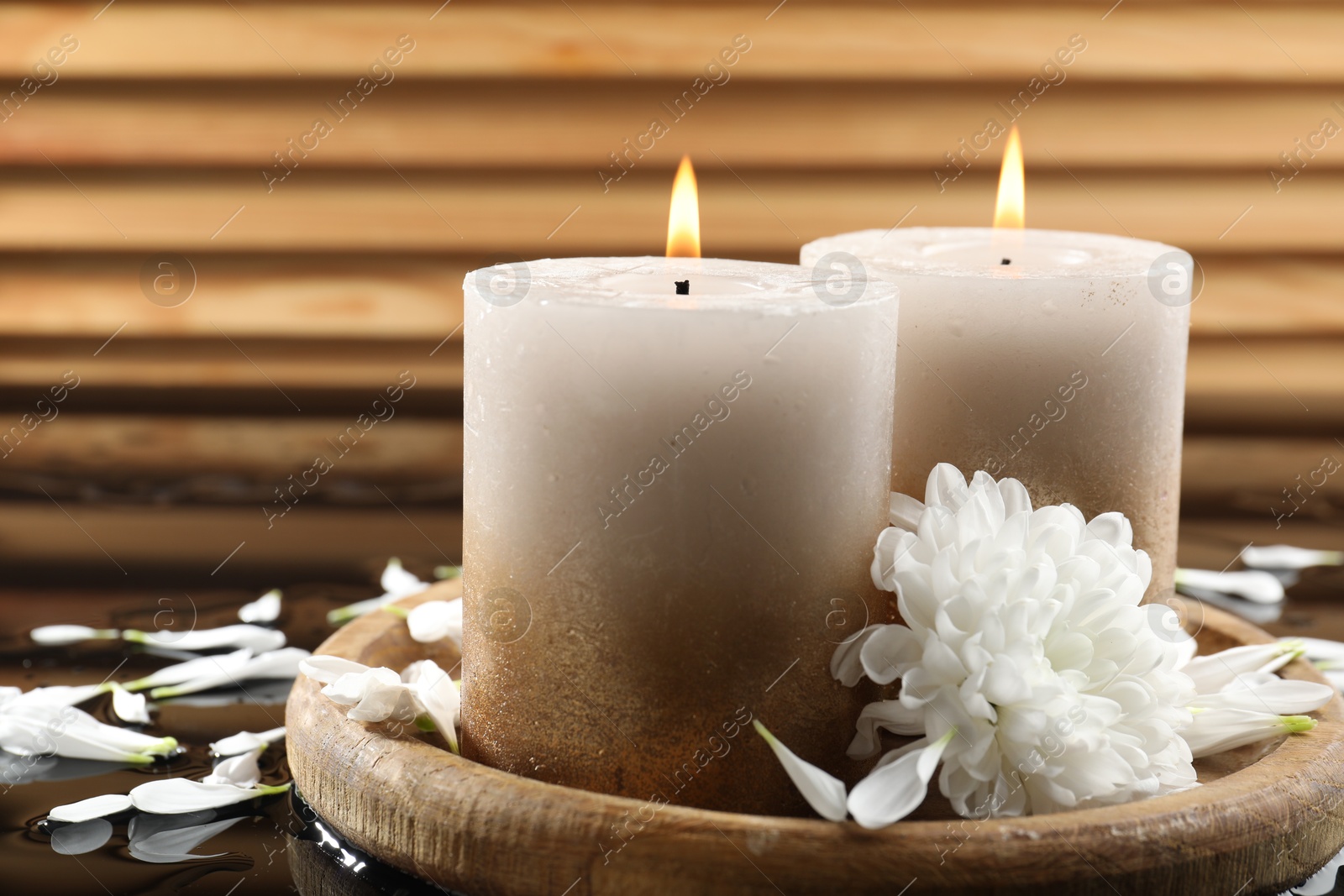 Burning candles and beautiful flowers on wet black mirror surface, closeup Photo of Burning candles and beautiful flowers on wet black mirror surface, closeup