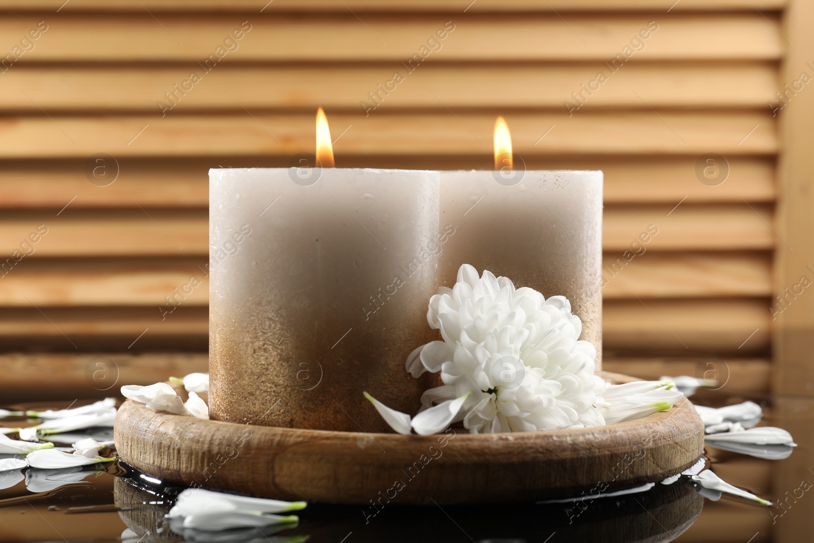 Burning candles and beautiful flowers on wet black mirror surface, closeup Photo of Burning candles and beautiful flowers on wet black mirror surface, closeup