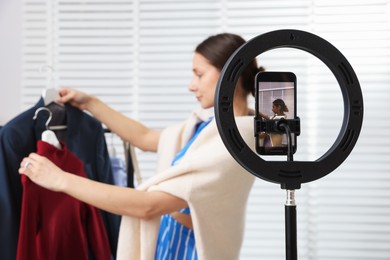 Photo of Professional stylist filming video on smartphone indoors