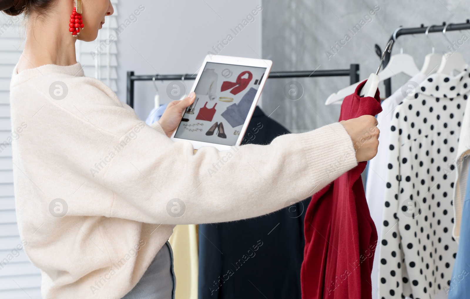 Professional stylist with picture of outfit on tablet working indoors Photo of Professional stylist with picture of outfit on tablet working indoors