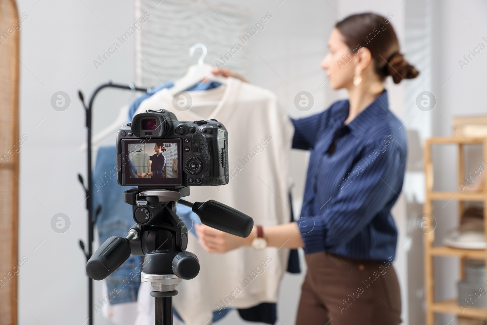 Photo of Professional stylist filming video on camera indoors, selective focus