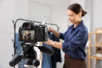 Photo of Professional stylist filming video on camera indoors, selective focus
