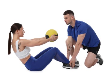 Photo of Coach training woman with medicine ball on white background