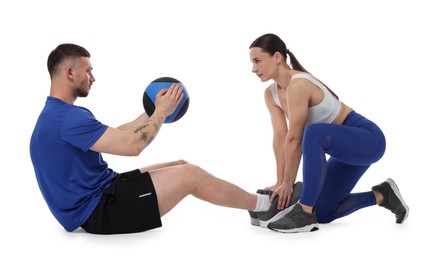 Photo of Coach training man with medicine ball on white background