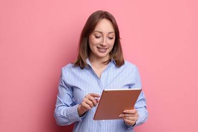 Photo of Woman with modern tablet on pink background