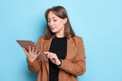 Photo of Woman with modern tablet on light blue background
