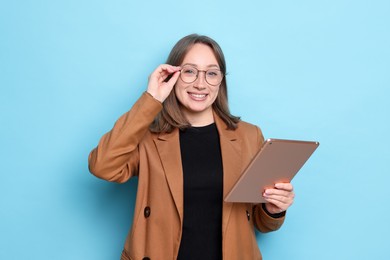Photo of Woman with modern tablet on light blue background