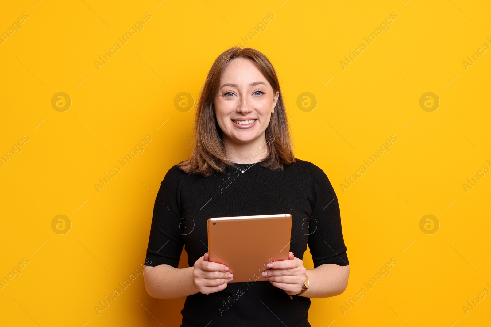 Woman with modern tablet on orange background Photo of Woman with modern tablet on orange background