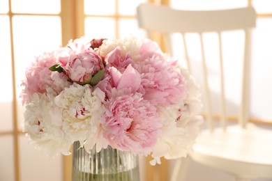 Photo of Beautiful peonies in vase indoors, closeup. Space for text