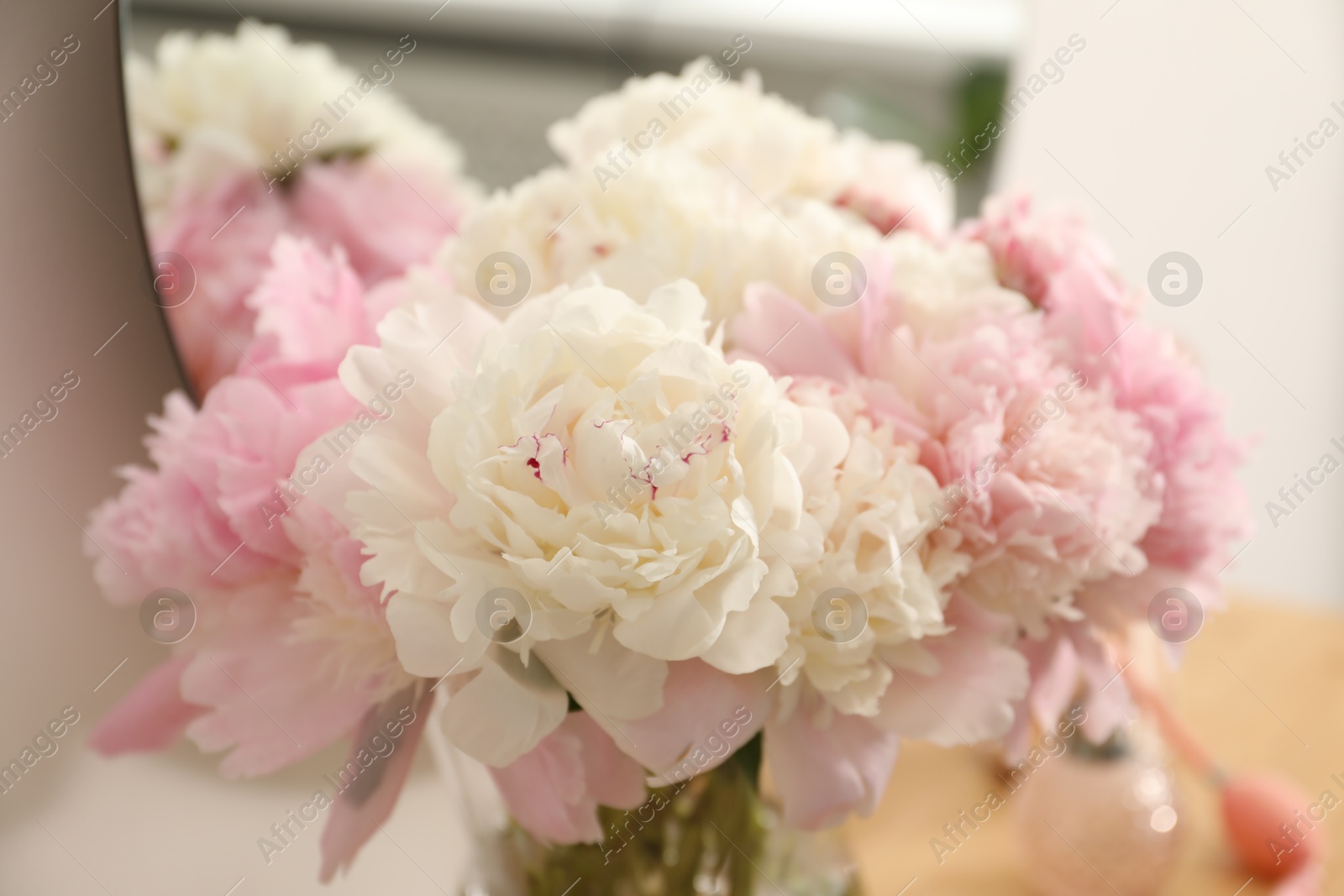 Beautiful peonies in vase on wooden vanity indoors, closeup Photo of Beautiful peonies in vase on wooden vanity indoors, closeup