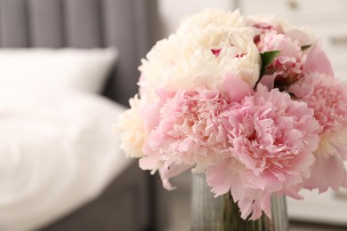 Photo of Beautiful peonies in vase indoors, closeup. Space for text