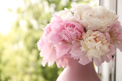 Photo of Beautiful peonies in vase on windowsill indoors, closeup