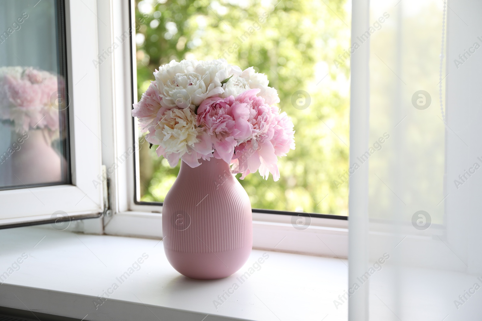 Beautiful peonies in vase on windowsill indoors Photo of Beautiful peonies in vase on windowsill indoors