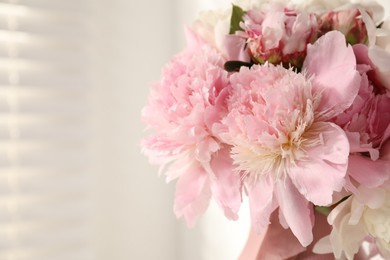 Photo of Bouquet of beautiful peonies in vase indoors, closeup. Space for text